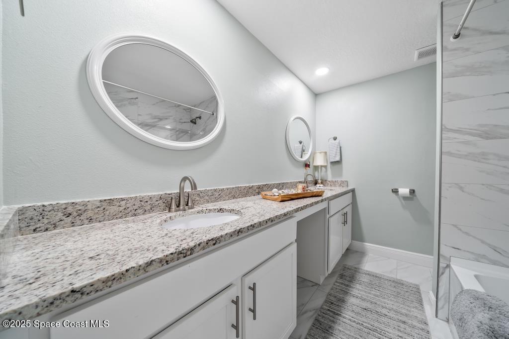 1253 St Andrews Drive Rockledge, FL 32955 - Photo 23 of 33 a bathroom with a granite countertop double vanity sink and a mirror