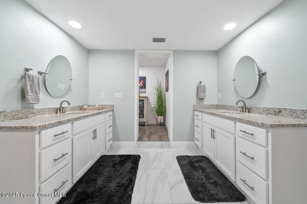 1253 St Andrews Drive Rockledge, FL 32955 - Photo 26 of 33 a spacious bathroom with double vanity and a mirror