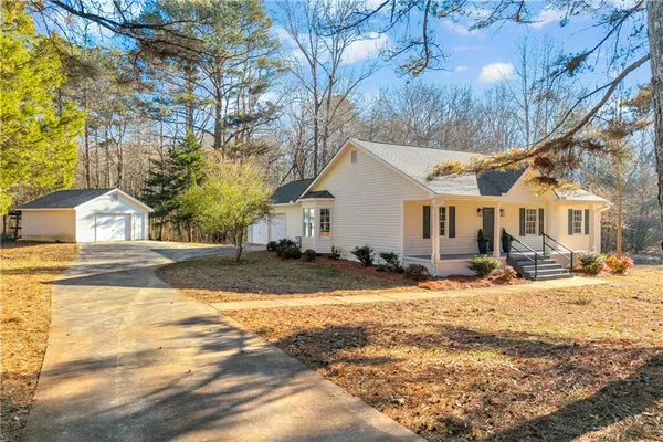 a view of a white house with a yard covered in snow
