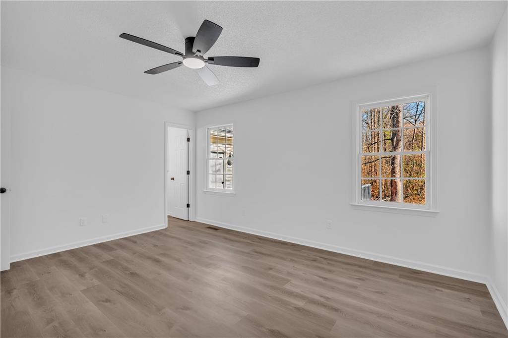 2693 Highway 101 Temple, GA 30179 - Photo 27 of 69 an empty room with wooden floor ceiling fan and windows
