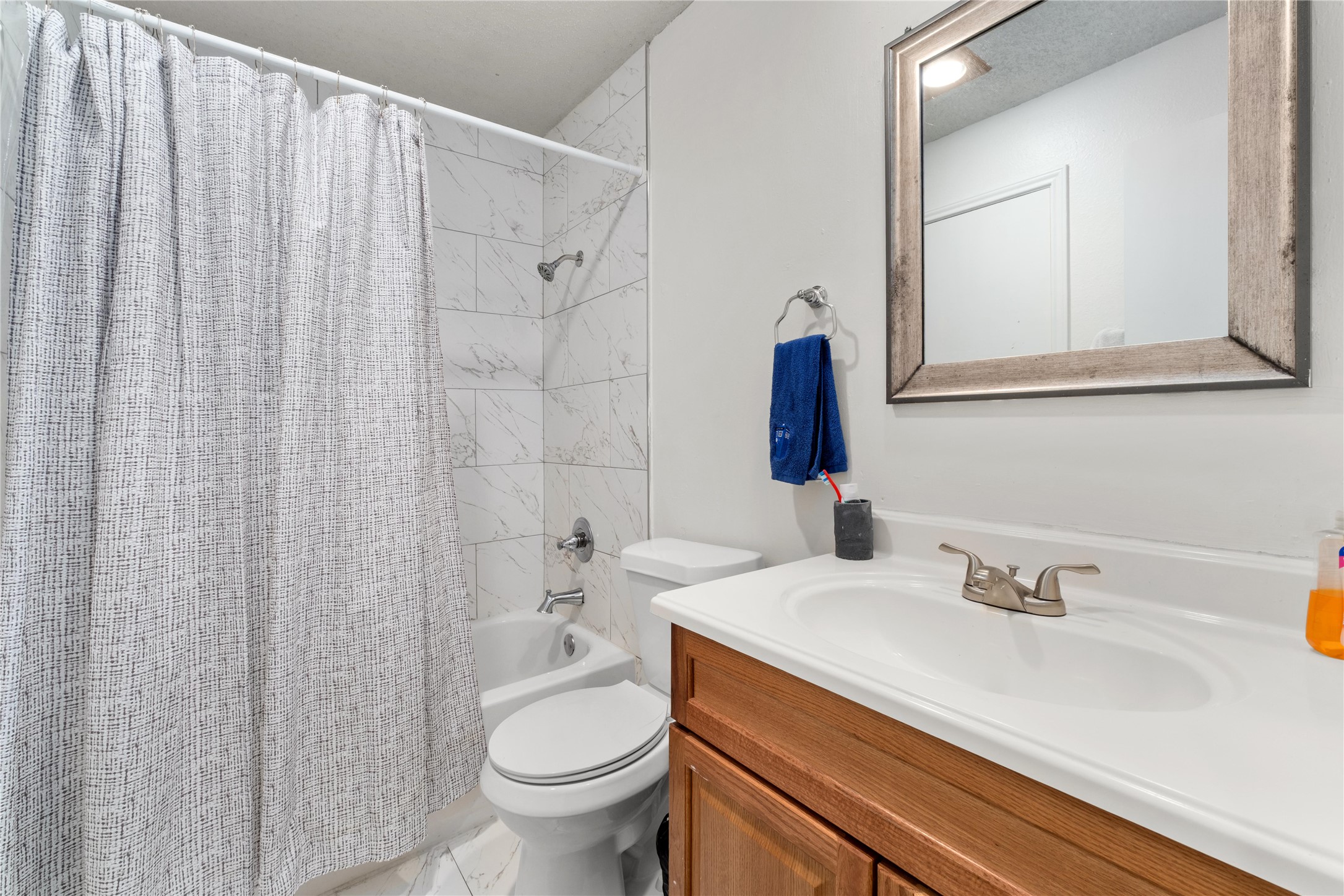 2409 Leon Street, Unit 307 Austin, TX 78705 - Photo 21 of 23 a bathroom with a sink a toilet and a mirror