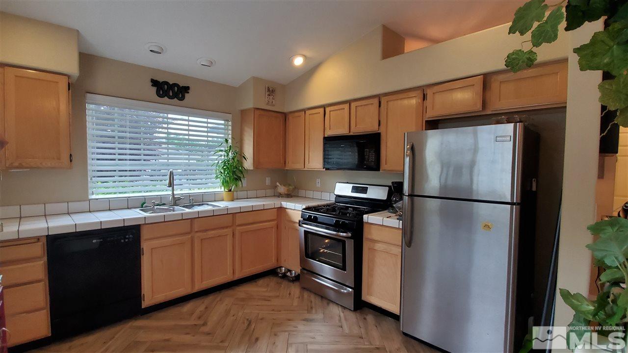 4580 Goodwin Road Sparks, NV 89436 - Photo 3 of 12 a kitchen with stainless steel appliances a sink cabinets and a refrigerator