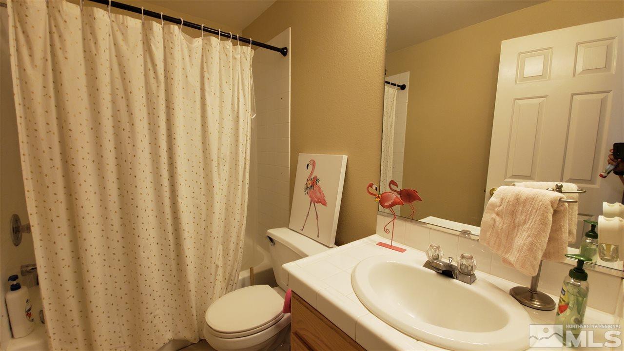 4580 Goodwin Road Sparks, NV 89436 - Photo 5 of 12 a bathroom with a sink a toilet and shower curtain