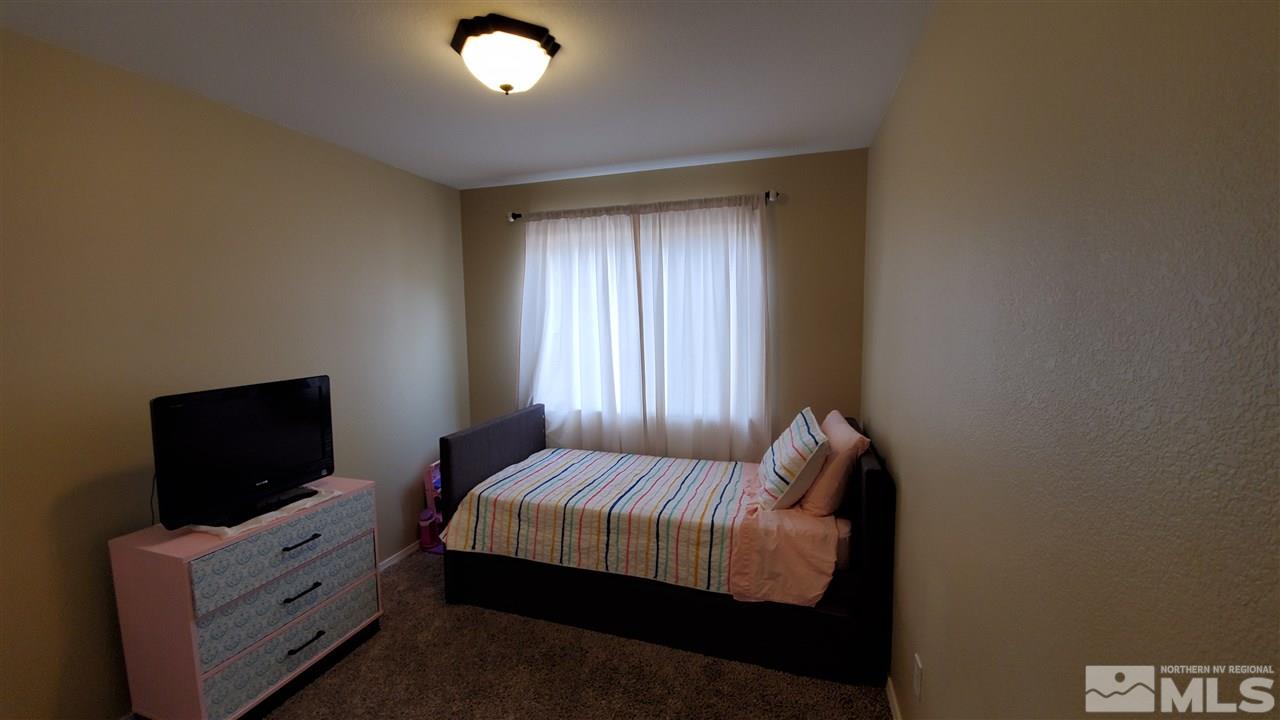 4580 Goodwin Road Sparks, NV 89436 - Photo 8 of 12 a bedroom with a bed and a flat screen tv