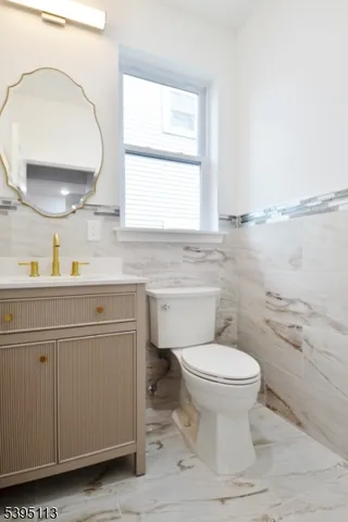 a bathroom with a granite countertop sink a toilet and a shower