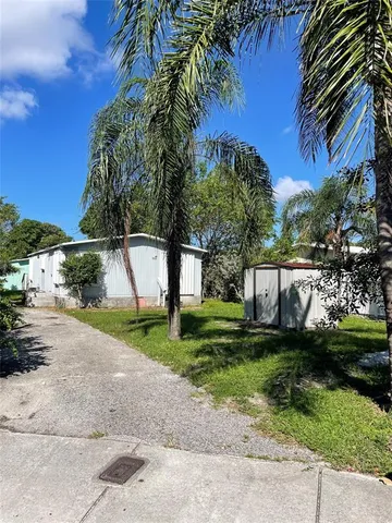 a view of a yard with plants and trees