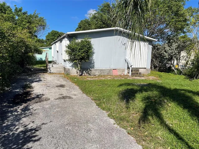 a view of a white house with a yard
