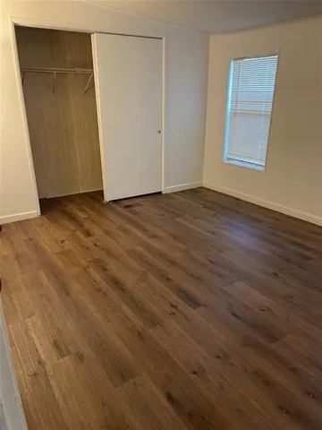 an empty room with wooden floor and entrance