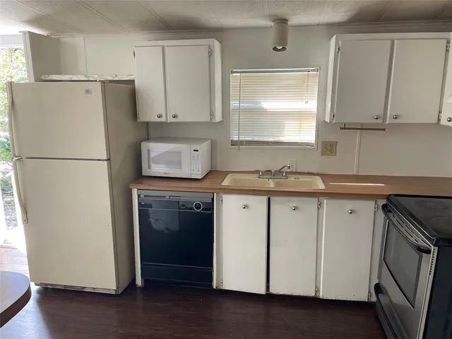 a kitchen with a refrigerator sink stove and cabinets