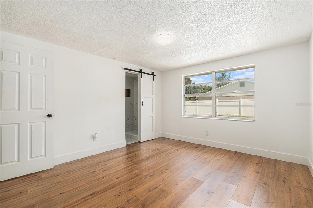 16147 Sagebrush Road Tampa, FL 33618 - Photo 11 of 18 a view of an empty room with wooden floor and a window