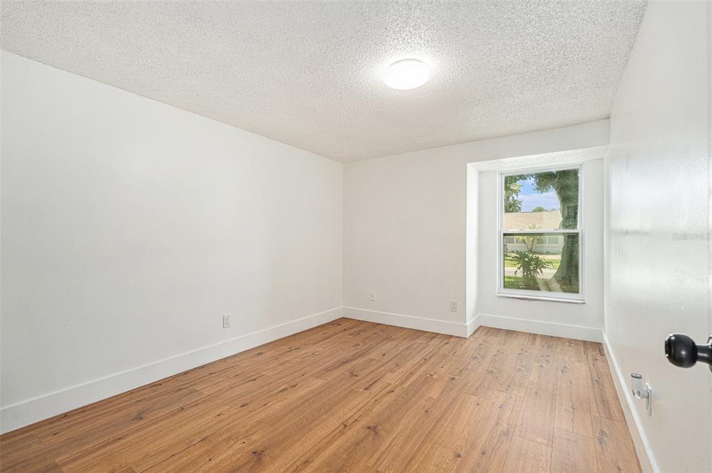 16147 Sagebrush Road Tampa, FL 33618 - Photo 14 of 18 an empty room with wooden floor and windows