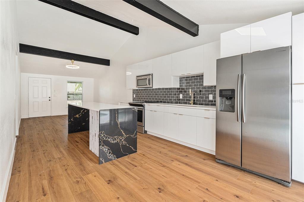 16147 Sagebrush Road Tampa, FL 33618 - Photo 3 of 18 a kitchen with stainless steel appliances a refrigerator and a stove top oven