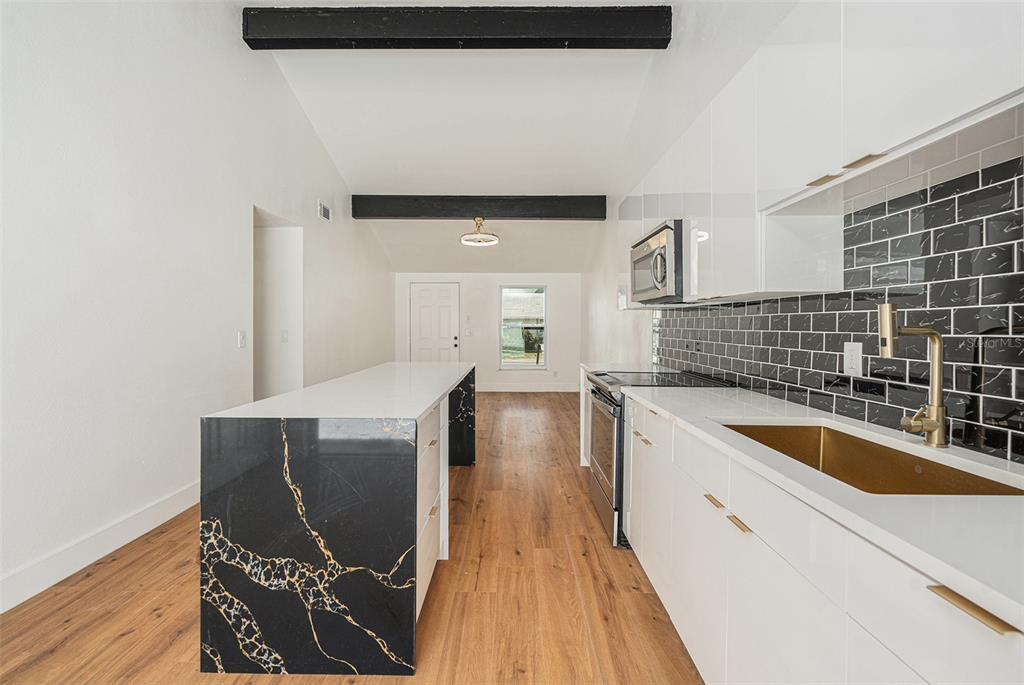 16147 Sagebrush Road Tampa, FL 33618 - Photo 5 of 18 a kitchen with granite countertop white cabinets and wooden floor