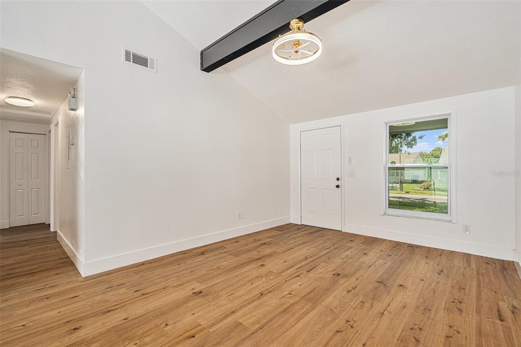 16147 Sagebrush Road Tampa, FL 33618 - Photo 7 of 18 an empty room with wooden floor and window