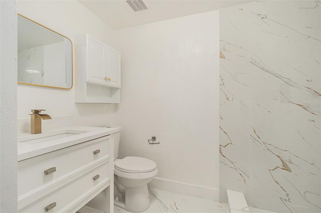 16147 Sagebrush Road Tampa, FL 33618 - Photo 8 of 18 a bathroom with a granite countertop toilet a sink a vanity and mirror