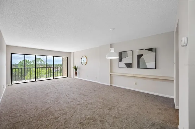 a view of empty room with kitchen