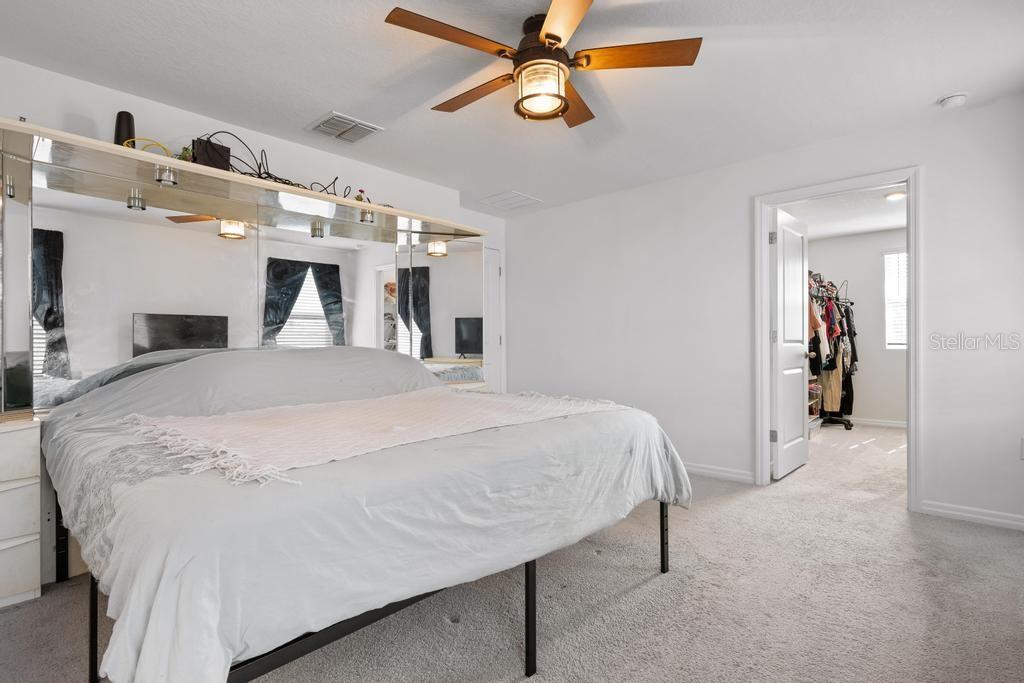 2986 Great Abaco Way Bradenton, FL 34208 - Photo 14 of 27 a spacious bedroom with a bed and ceiling fan