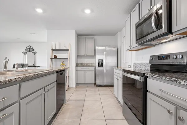 a kitchen with stainless steel appliances granite countertop a stove a sink and a microwave