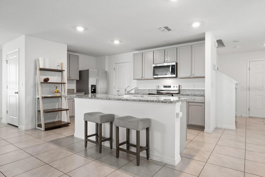 2986 Great Abaco Way Bradenton, FL 34208 - Photo 5 of 27 a kitchen with stainless steel appliances granite countertop a refrigerator and a stove top oven