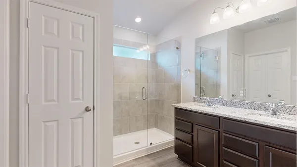 a bathroom with a granite countertop sink a toilet and shower
