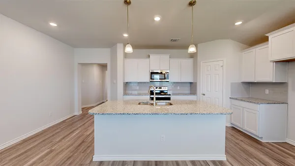 a kitchen with a sink chandelier and fireplace