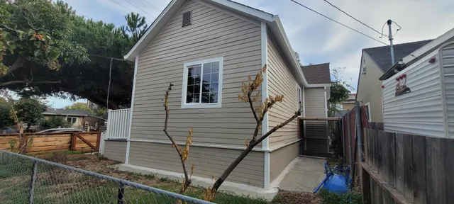 a view of a house with backyard and trees