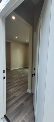 a view of hallway with stairs and wooden floor