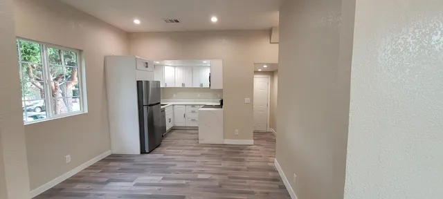 a view of kitchen with wooden floor electronic appliances and furniture