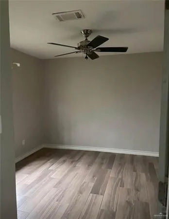 a view of a room with wooden floor cabinet and a window