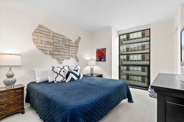 a bedroom with a bed a dresser and a book shelf