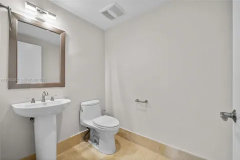 a bathroom with a toilet a sink a mirror and a shower