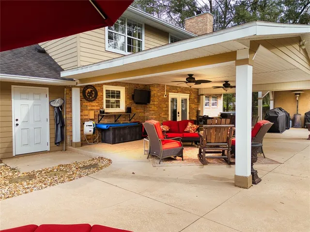 a view of a patio with table and chairs and potted plants and large trees