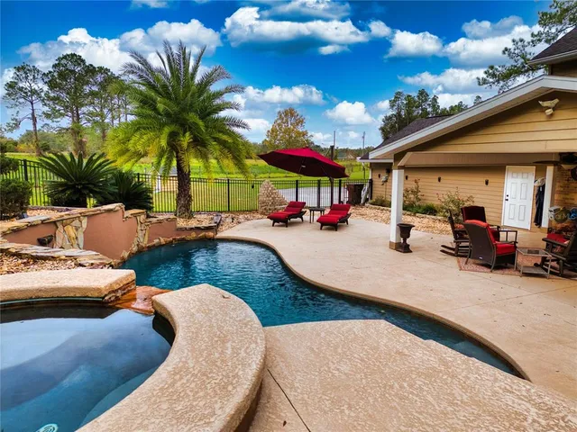 an aerial view of a residential houses with yard and swimming pool