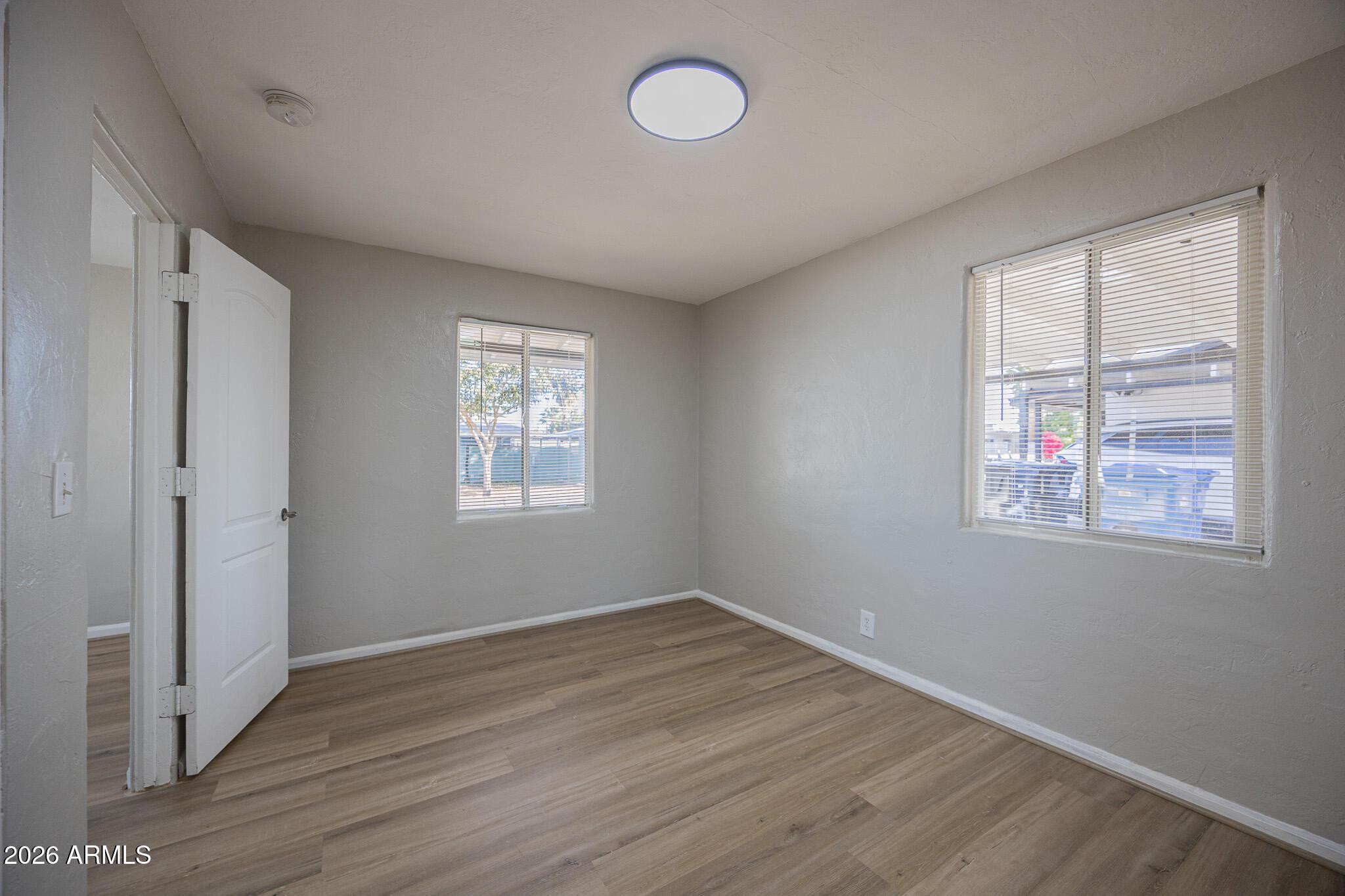 4208 North 17th Street, Unit 2 Phoenix, AZ 85016 - Photo 11 of 18 an empty room with wooden floor and windows