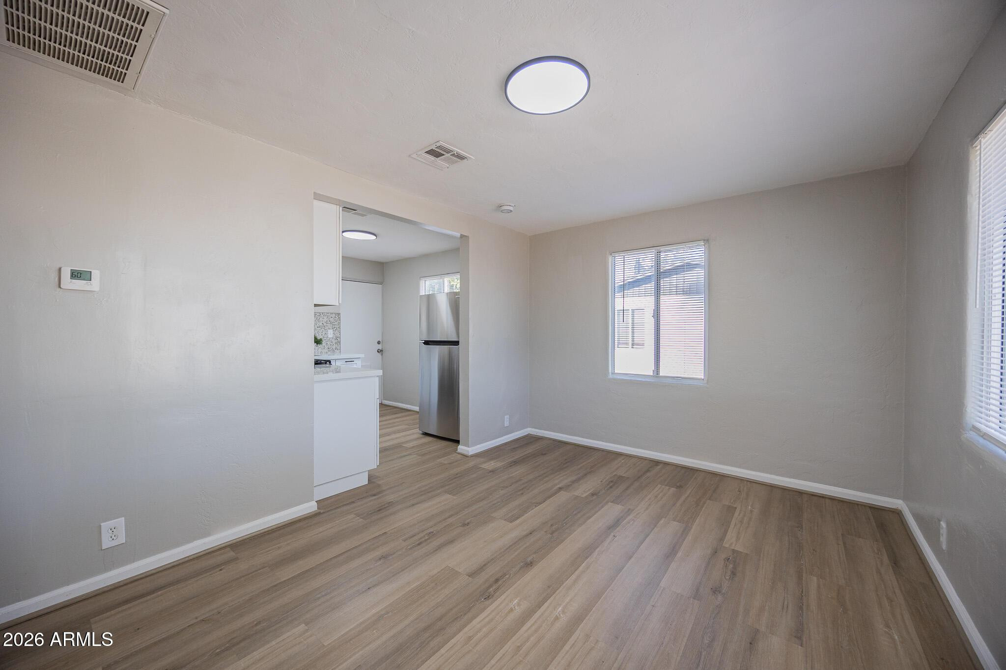 4208 North 17th Street, Unit 2 Phoenix, AZ 85016 - Photo 7 of 18 an empty room with wooden floor and windows