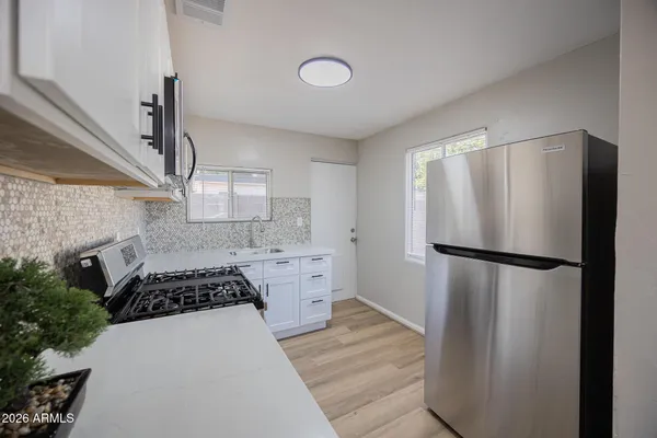 a kitchen with a refrigerator and a stove