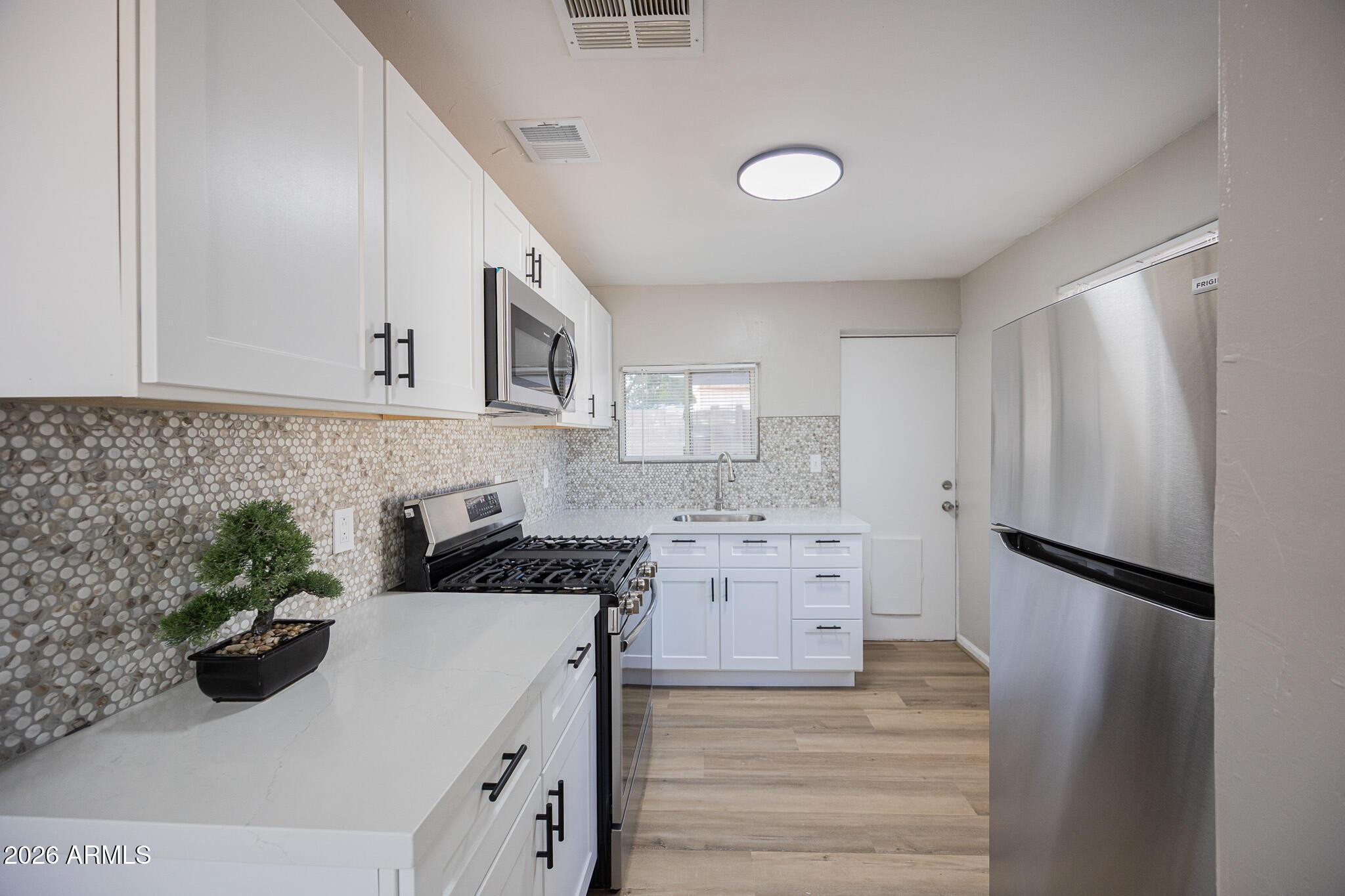 4208 North 17th Street, Unit 2 Phoenix, AZ 85016 - Photo 9 of 18 a kitchen with a sink stove and refrigerator