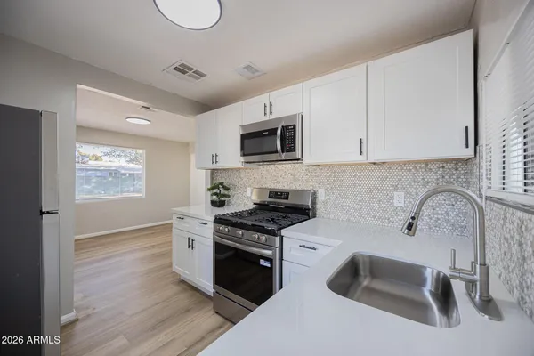 a kitchen with granite countertop a sink and a stove top oven