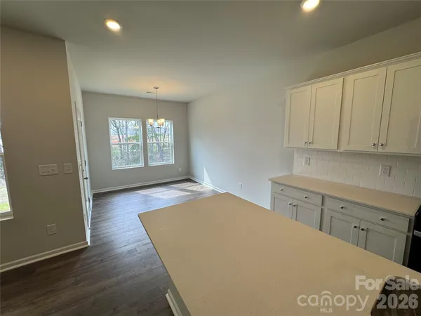 a view of a kitchen with wooden floor and electronic appliances