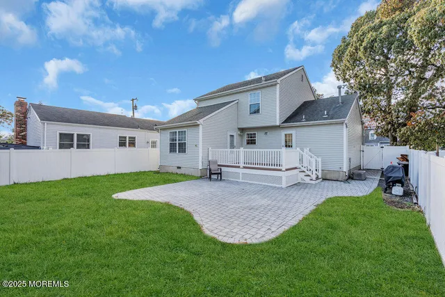 a view of a house with a backyard and a tree