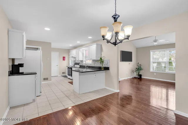 a kitchen with stainless steel appliances granite countertop a stove refrigerator and cabinets