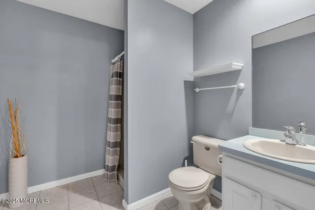 a bathroom with a granite countertop toilet and a sink