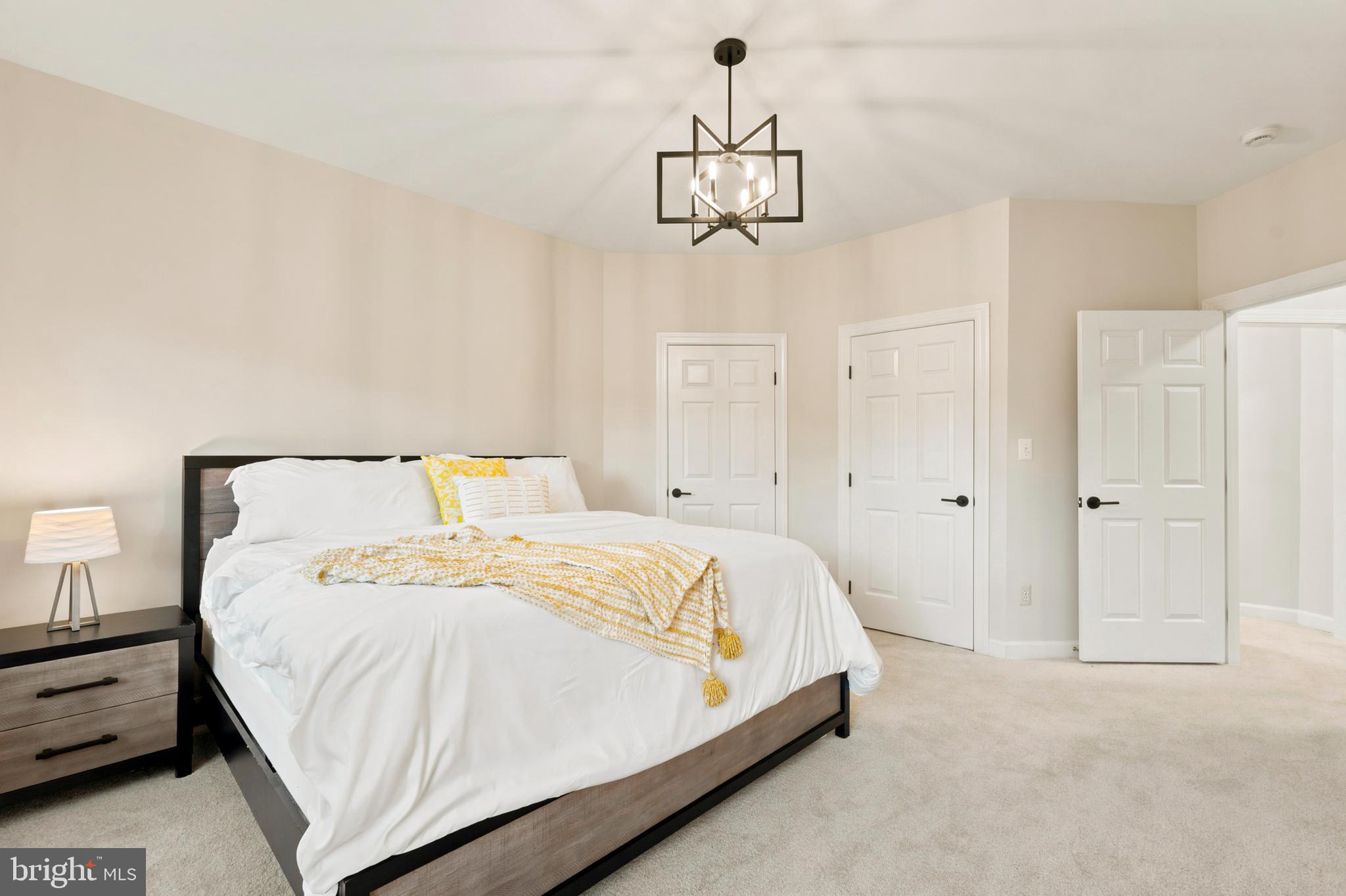 9313 Harrisons Farm Way Laytonsville, MD 20882 - Photo 31 of 77 a large bed sitting in a bedroom and chandelier