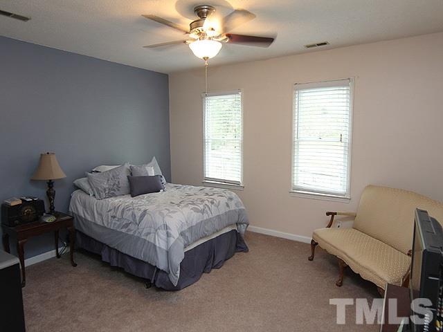 5412 Middleton Road Durham, NC 27713 - Photo 11 of 18 a spacious bedroom with a bed and a chandelier