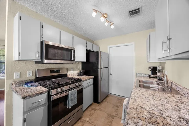 a kitchen with a stove a sink and a refrigerator