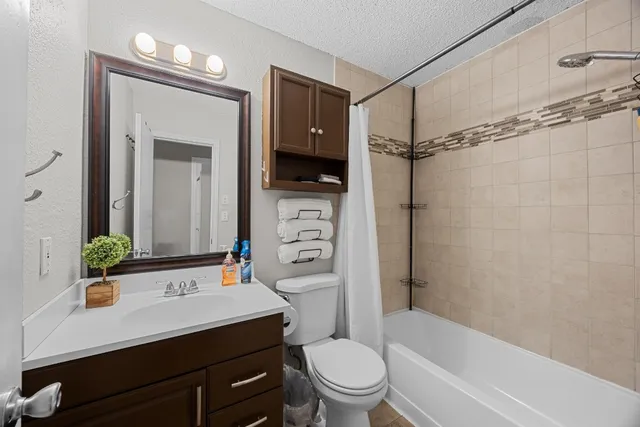 a bathroom with a sink a toilet a mirror and shower