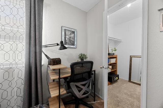 a view of a workspace with furniture and a window