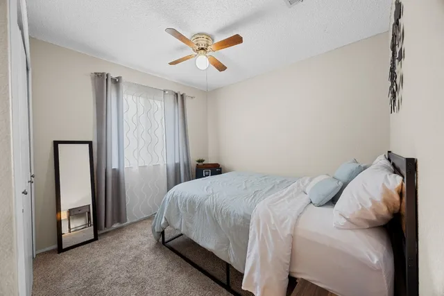 a bedroom with a bed and a ceiling fan