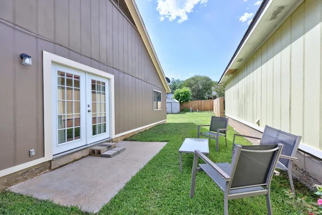 a view of backyard of house with outdoor seating and green space