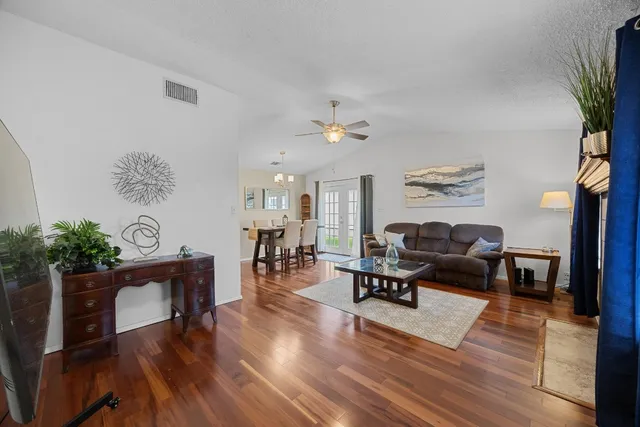 a living room with furniture and a wooden floor